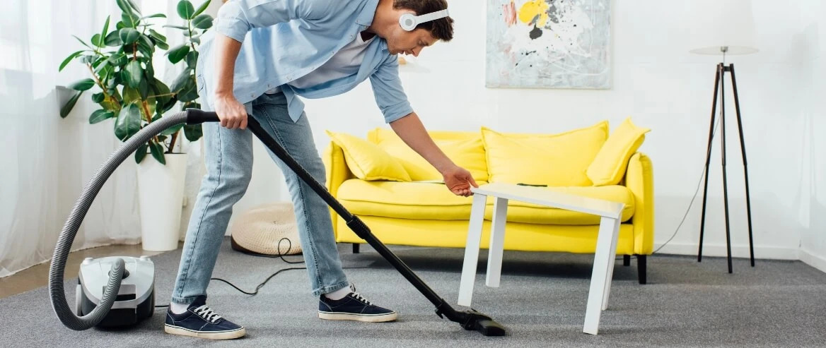 Man Vacuuming Carpet While Listening To Music