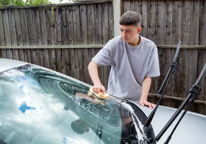 teenage boy washing car