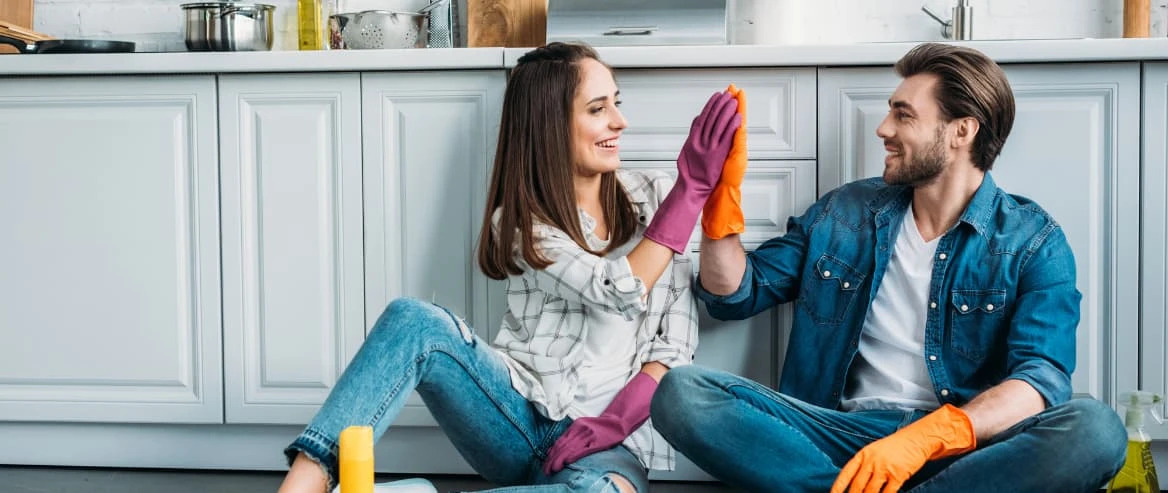 couple sitting in kitchen having fun doing spring cleaning