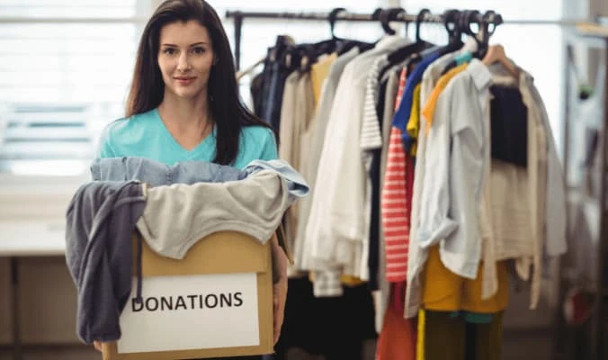 woman holding a box of clothes for donation