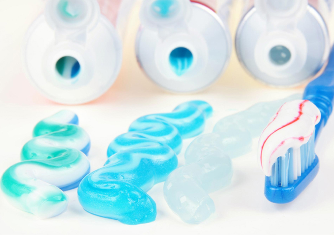 A three different toothpaste that squeeze out with blue toothbrush