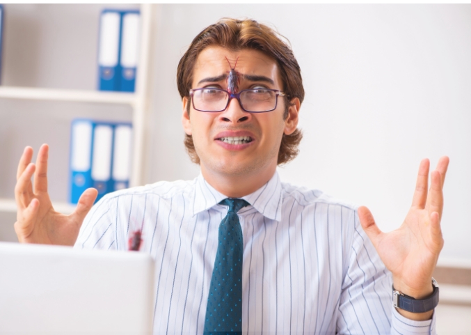 Man looking shocked after spotting a cockroach in his home.