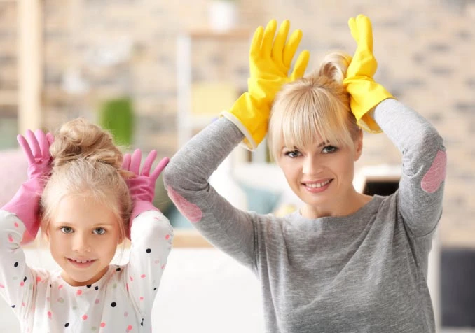 mother and daughter making silly post while cleaning