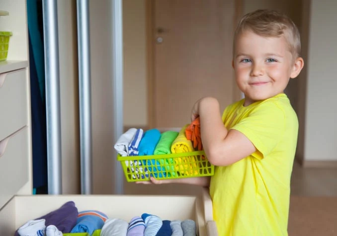 proud boy while putting his clothes back in the drawer