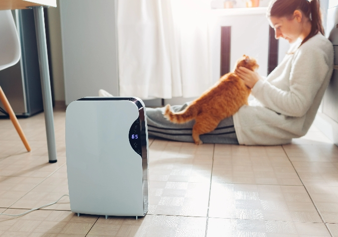 woman and cat near an air purifier