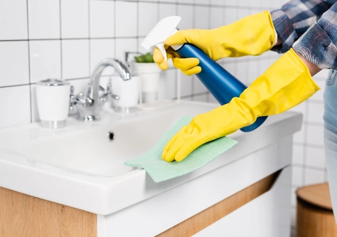 Cleaning bathroom tap and chrome surface with rubbing alcohol for streak-free shine