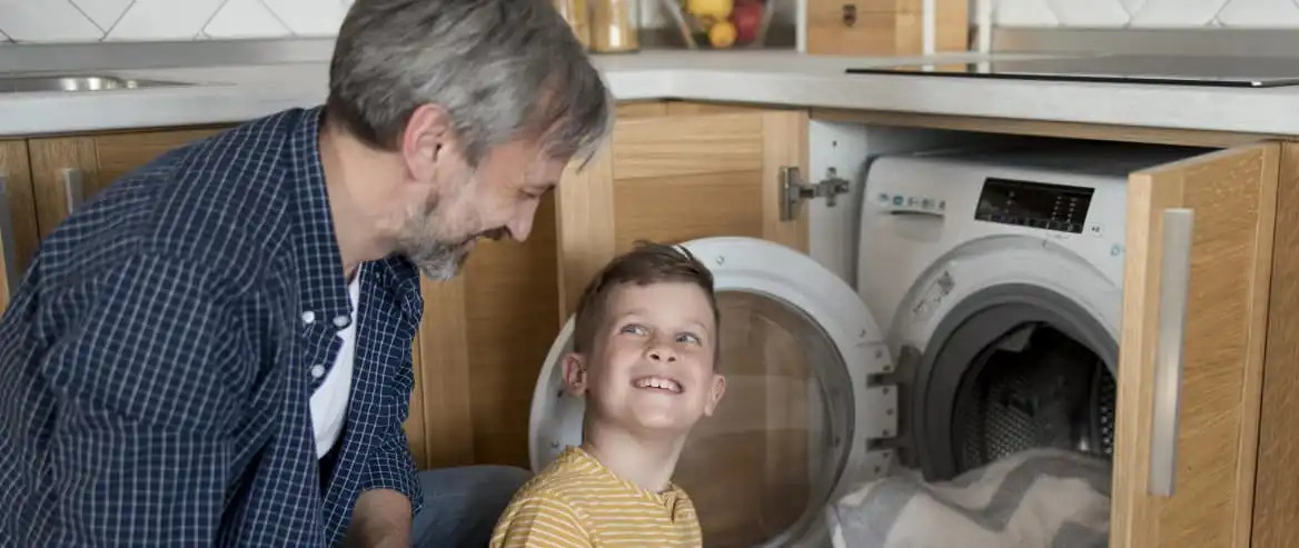 Father Teaching Son How To Do Laundry