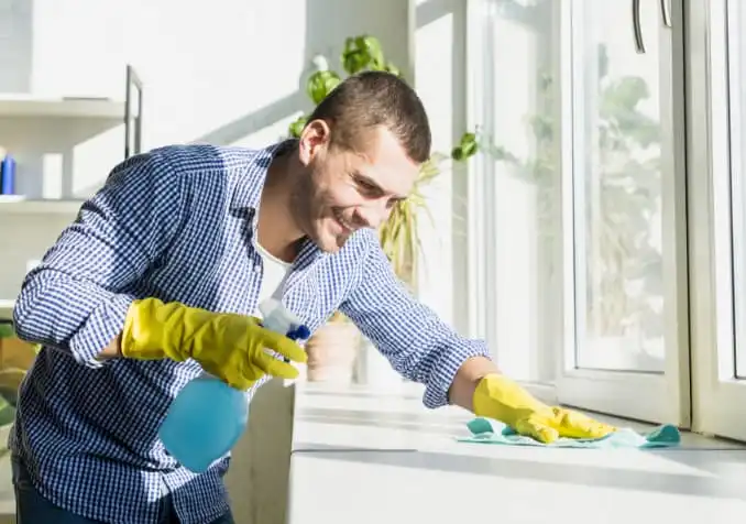 man cleaning with spray and cloth for open house