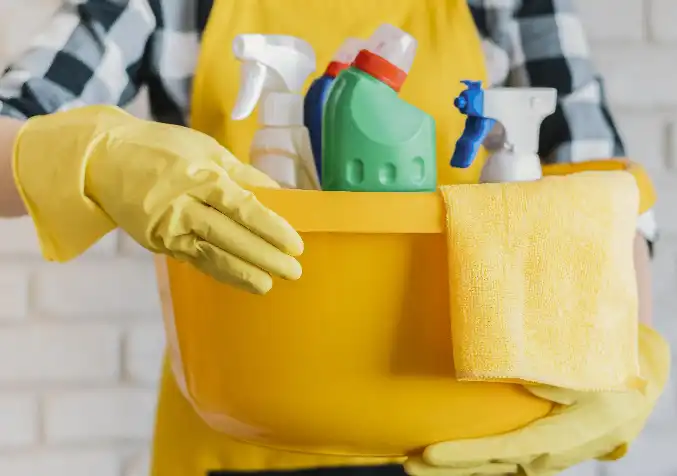 person holding a variety of cleaning products