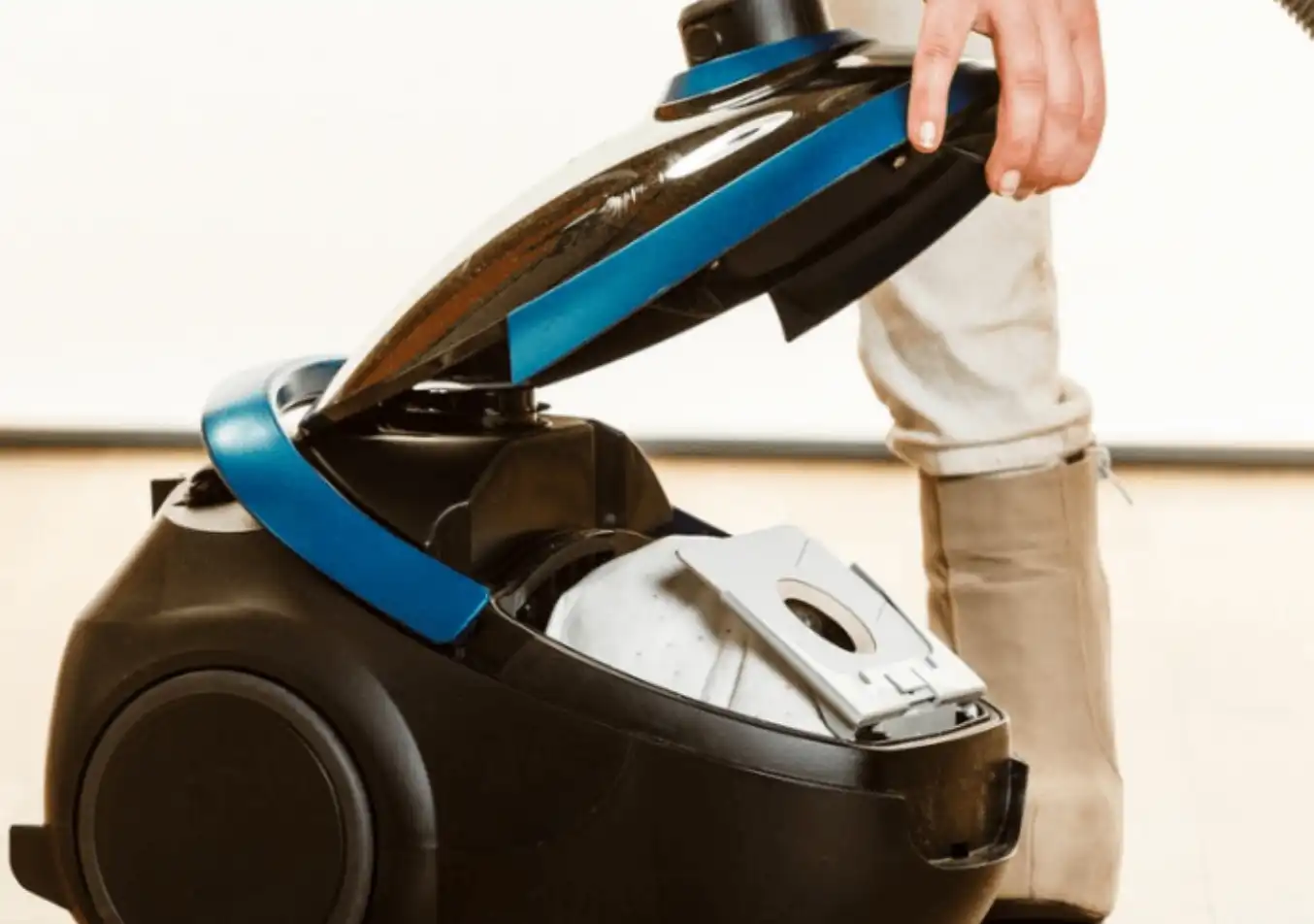 person cleaning the vacuum filter