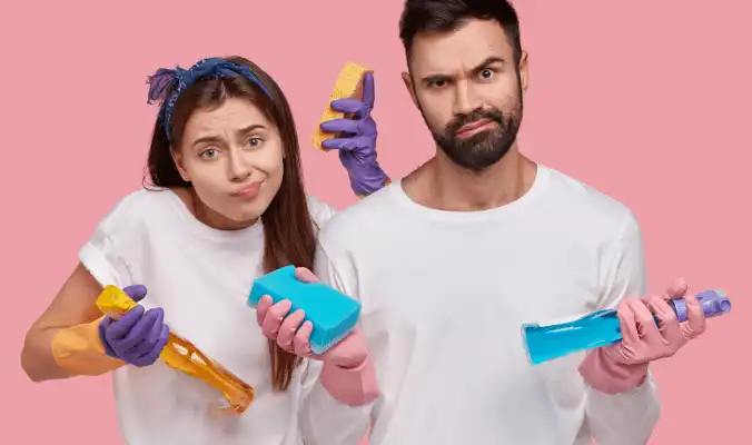 couple holding bathroom cleaning products