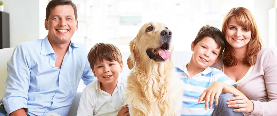 happy family sitting in the living room with pet dog