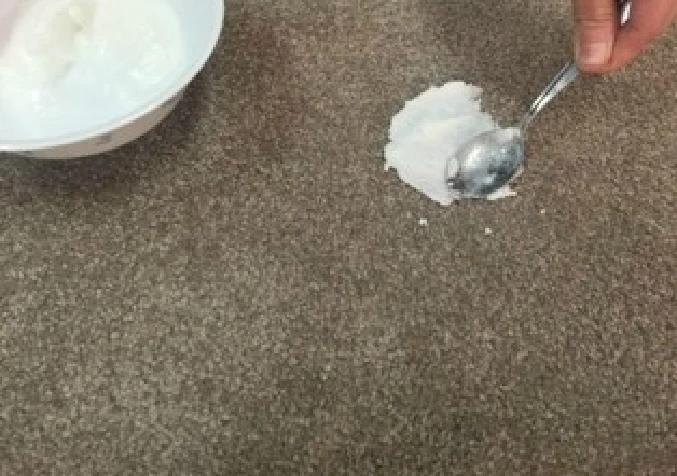 applying bi-carb paste on vomit stained carpet