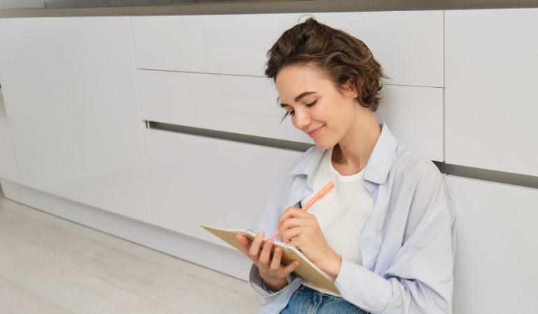 Person preparing checklist on the kitchen