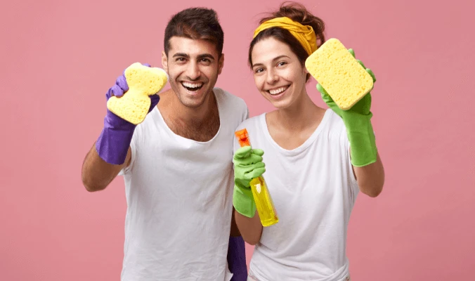 happy couple with cleaning materials