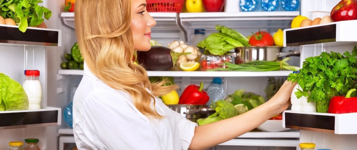 Woman Looks At Her Full Fridge Rack (1)