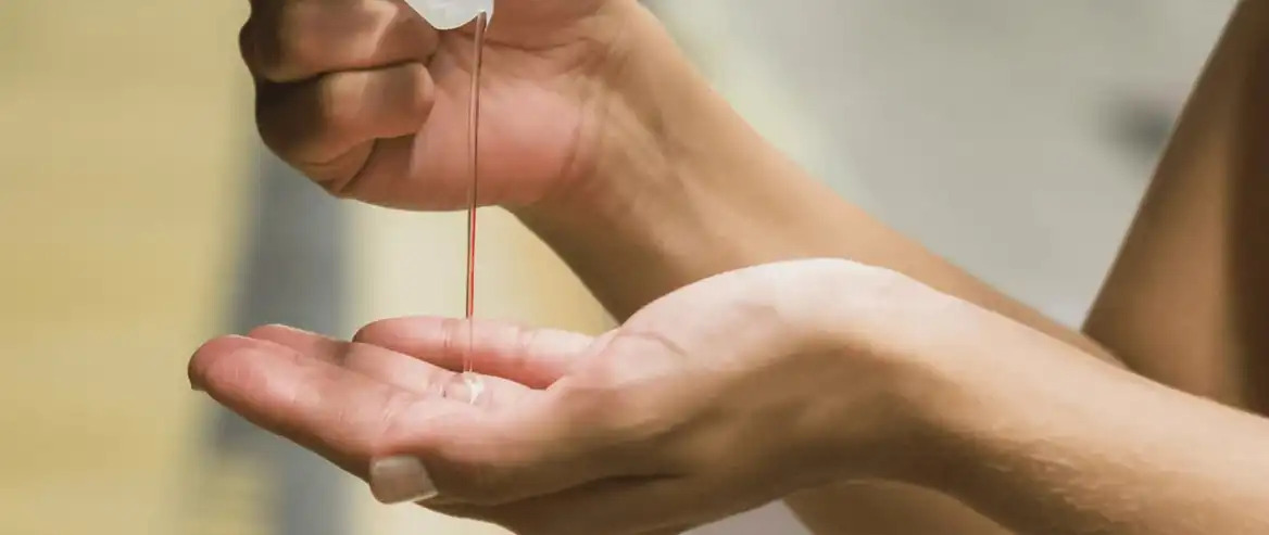 person squeezing hand sanitiser onto their hand