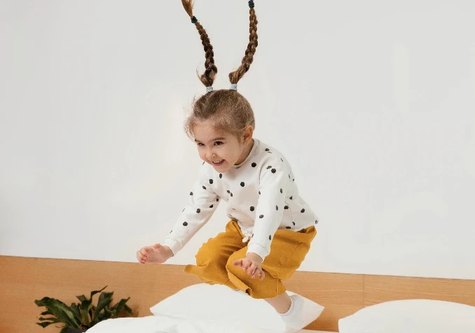 young girl jumping on mattress