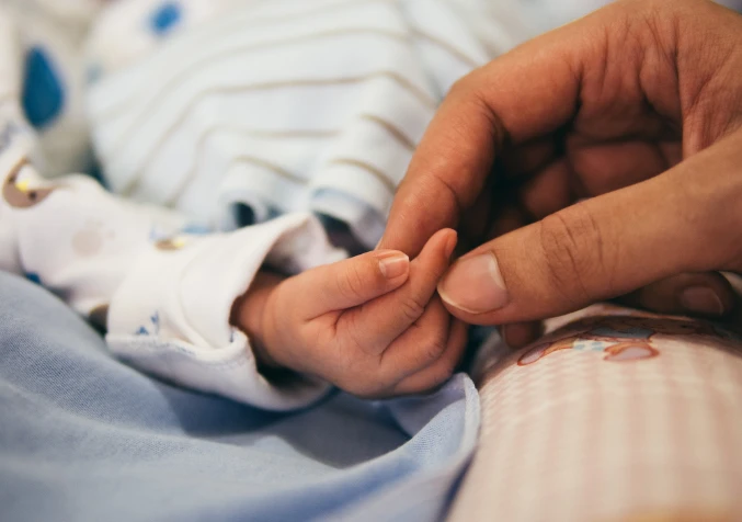 holding new bonr baby's hand