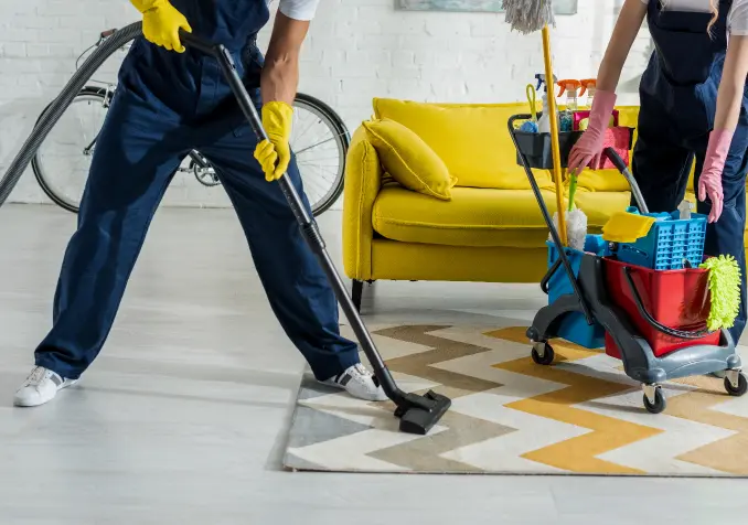 hired cleaners vacuuming rug