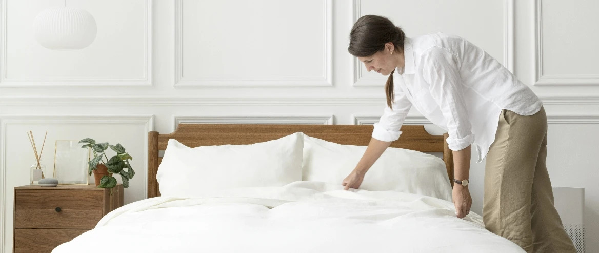 Woman Fixing Mattress Bedsheet