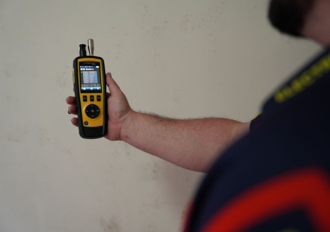 Electrodry technician measuring indoor air quality during mould inspection