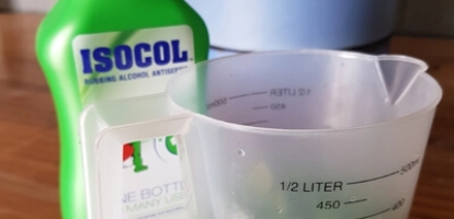 Isocol Bottle next to a measuring cup