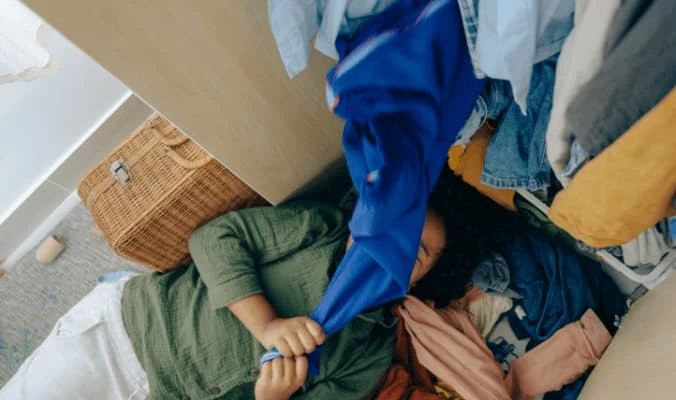 woman laying down while organising closet