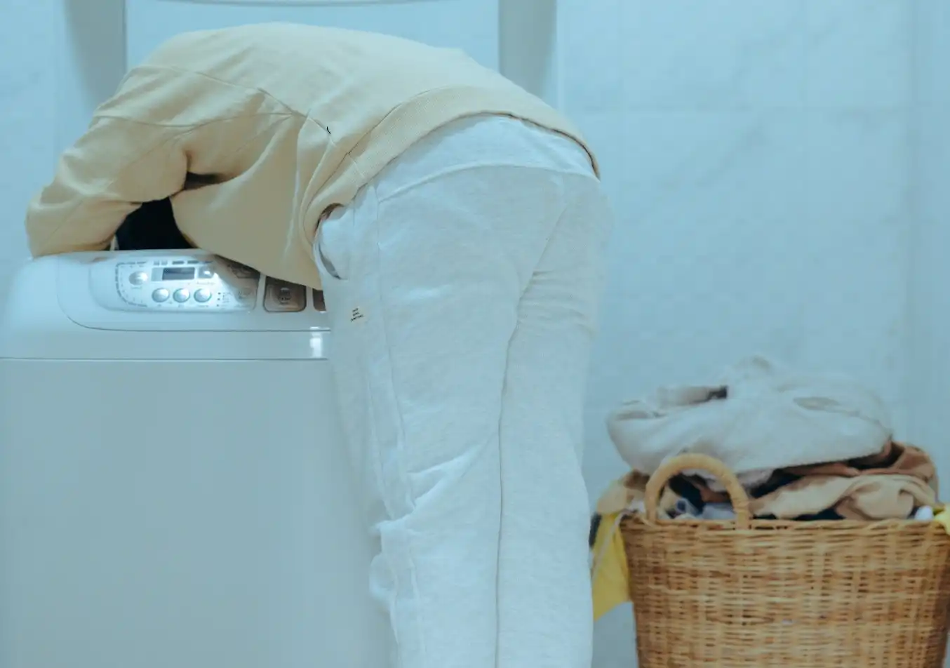 person reaching inside a washing machine