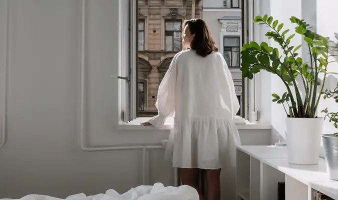 woman getting fresh air through an open window