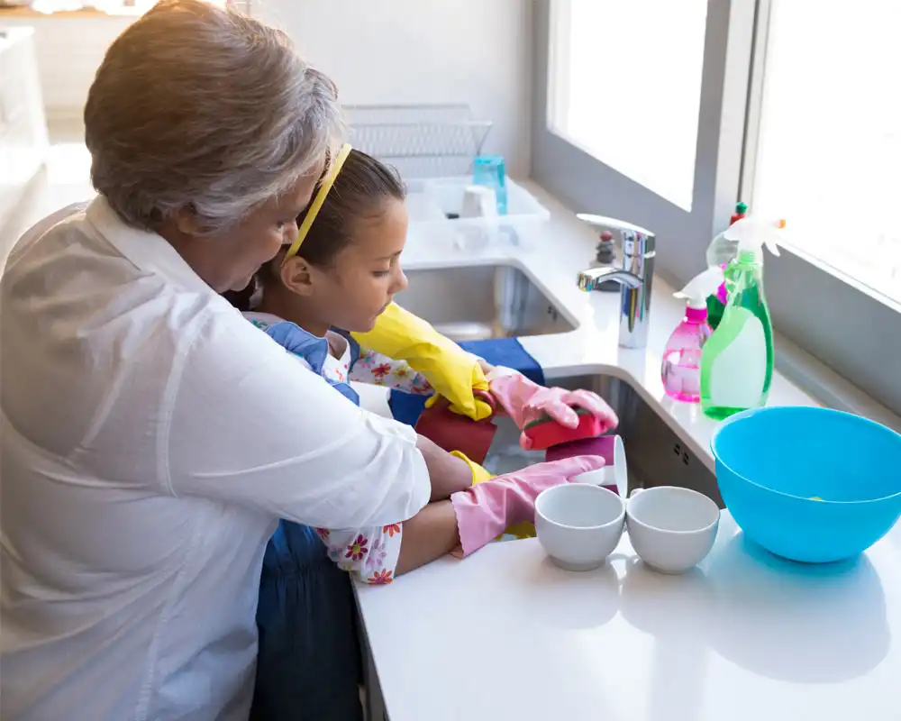 grandparent teaching grandchild how to clean