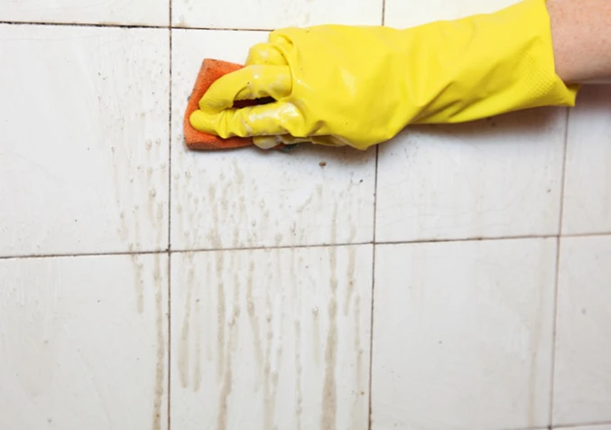 scrubbing bathroom walls with dirty sponge