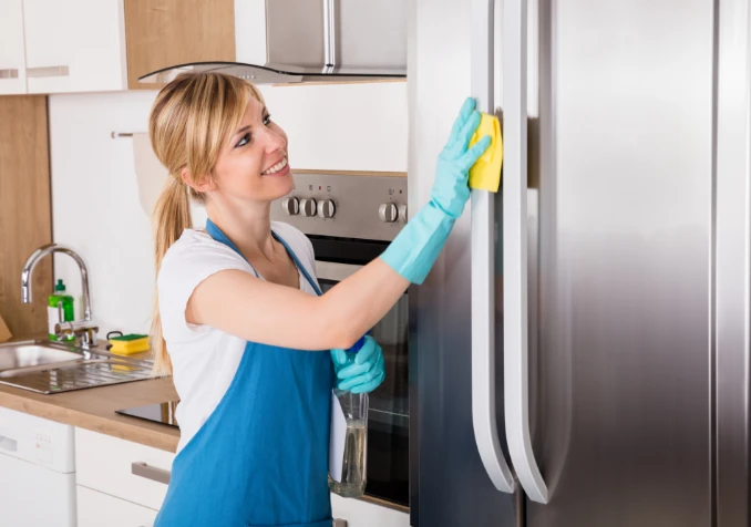 woman cleaning fridge exterior