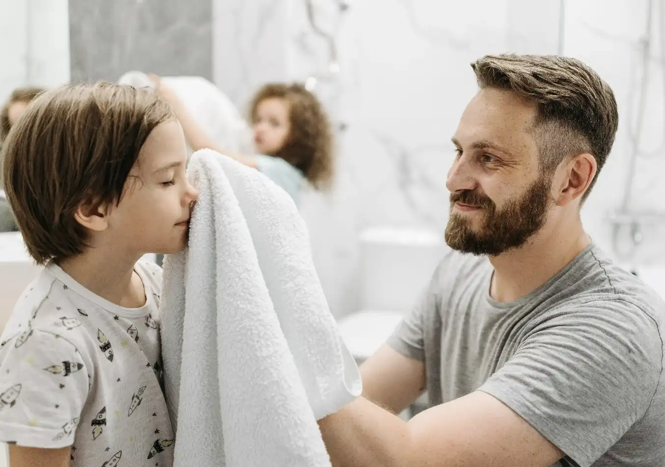 parent wiping child's face with a towel