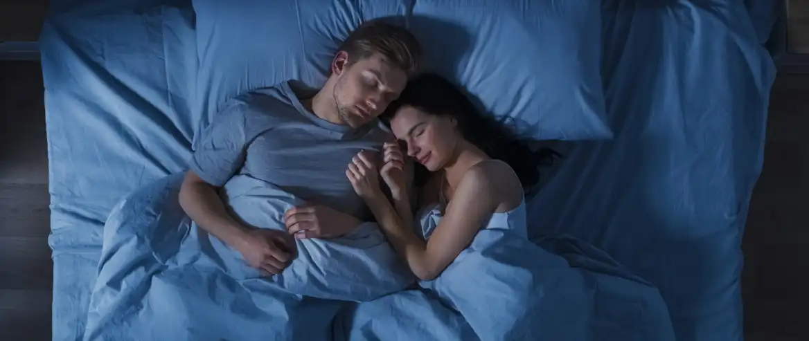 couple sleeping on blue sheets