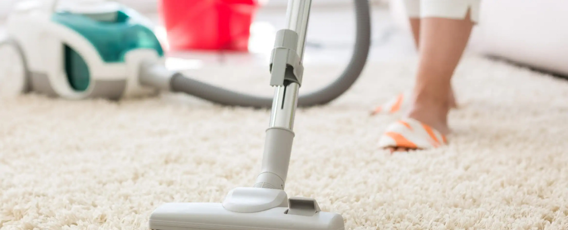 person properly using a vacuum to clean a carpet