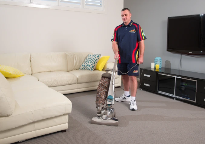 Electrodry carpet cleaning technician vacuuming customer's carpet prior to cleaning