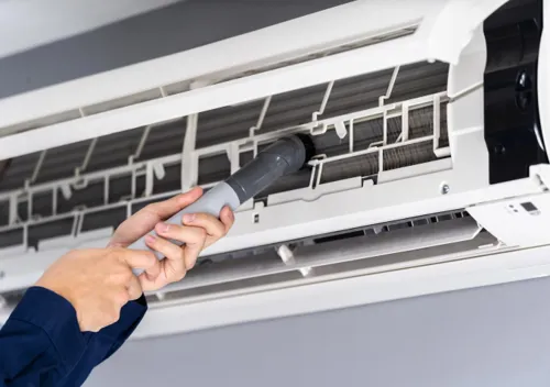 Cleaning a split-system air conditioner filter to improve airflow and efficiency.