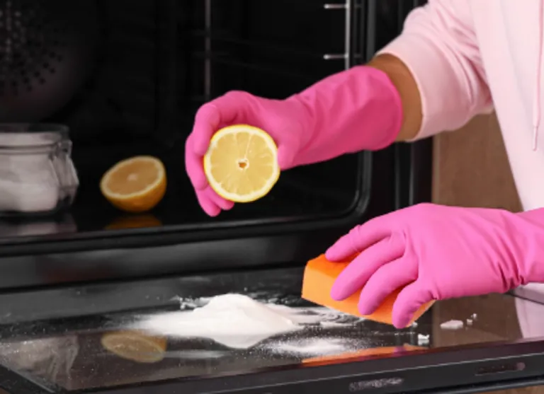 Clean modern oven door and lemons on kitchen bench showing natural oven cleaning method.