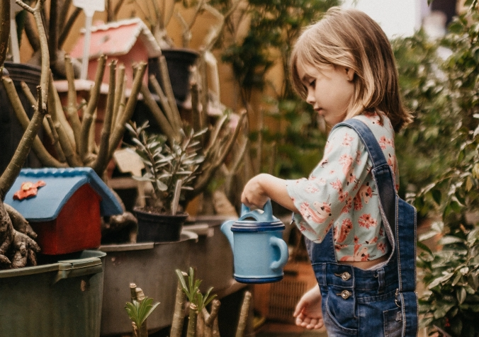 toddler watering the plants