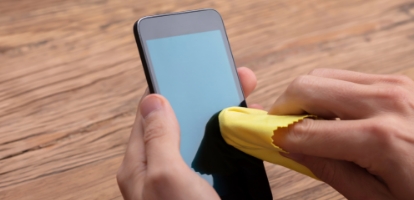 Hand wiping a scratched surface with a soft cloth to reduce light marks.