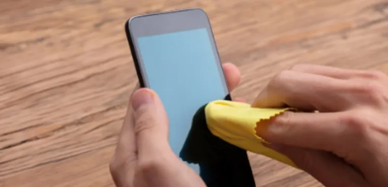 Hand wiping a scratched surface with a soft cloth to reduce light marks.