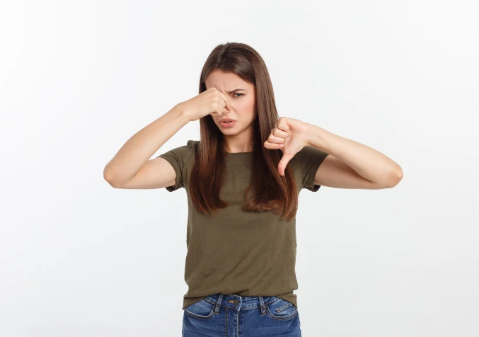 woman pinching nose because of stinky carpet