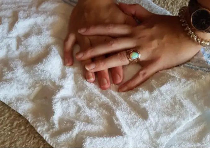 person pressing down on a carpet using a rug to remove stain