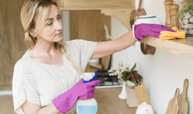 woman cleaning pantry shelves