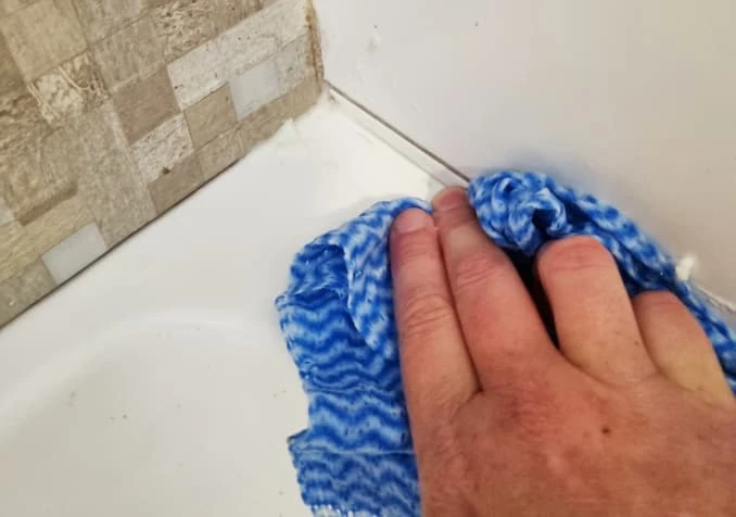 wiping grimy bathroom floor edge