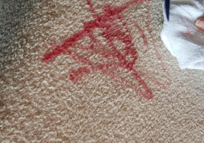 scraping off lipstick from carpet using butter knife and cloth