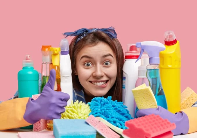happy woman with cleaning supplies