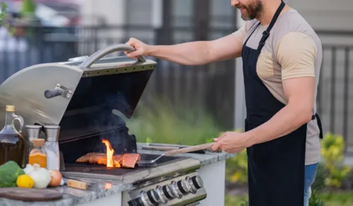 Cooking outdoors on a barbecue to reduce indoor heat and air conditioner load.