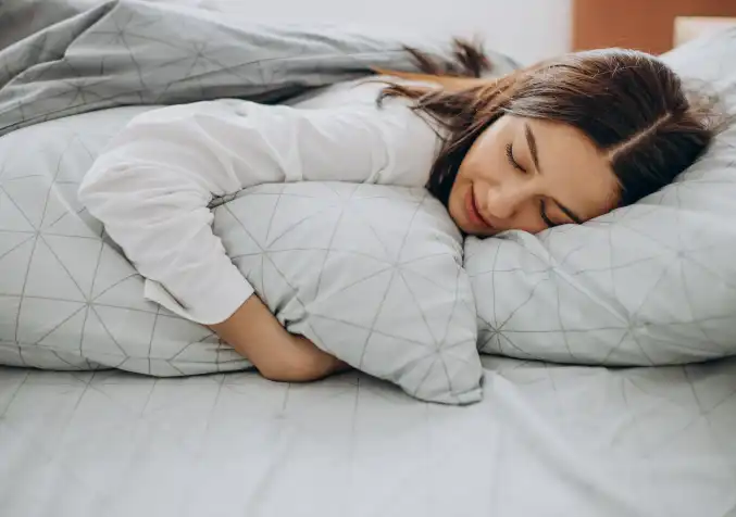 woman hugging a pillow while sleeping